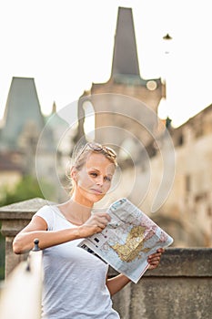 Pretty young female tourist studying a map