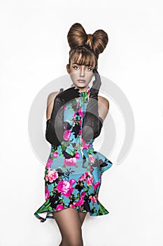 Pretty young girl beauty portrait. Elegant Fashion Glamorous teen Model wearing black Glamour Gloves and floral dress. Bow