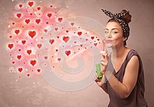 Pretty young girl blowing red heart symbols