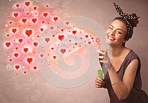 Pretty young girl blowing red heart symbols