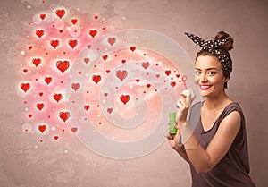 Pretty young girl blowing red heart symbols