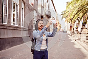 Pretty young girl with cell phone and backpack