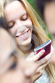 Pretty young girl chatting with smartphone