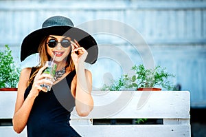 Pretty young girl drink cold coctail outdoor in beach cafe