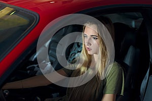 Pretty young girl driving a red sports car