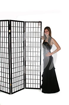 Pretty young girl in formal gown next to screen