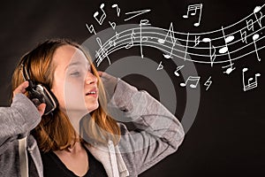 Pretty young girl listening to music on headphones