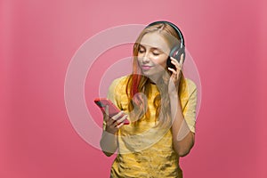 Pretty young girl listening to music on mobile phone with wired headphones enjoying sound. Musical apps advertising