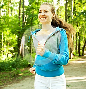 Pretty young girl runner in the forest.