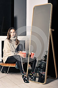pretty young girl is sitting on a chair in leather trousers