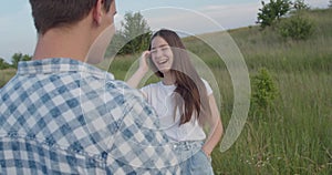 Pretty young girl smiling during a joyful talk with guy on a walk out of city