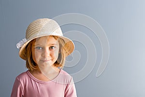 Pretty young girl in straw hat and pink shirt