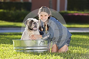 Pretty Young Girl Washing Her Pet Dog In A Tub