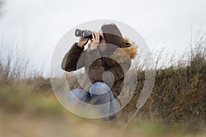 Pretty young girl / woman watching out by ornitology telescope t