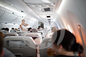 Pretty, young happy woman aboard an airplane during a lang haul commercial flight