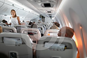 Pretty, young happy woman aboard an airplane photo