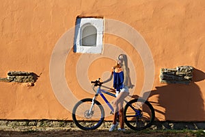 Pretty young hipster blonde girl posing with sport bicycle