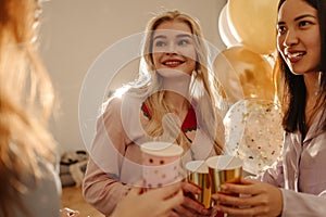 Pretty young interracial girls celebrating bachelorette party with close friends drinking drinks.