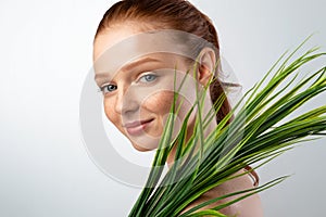 Pretty Young Lady Holding Green Plant Standing Over Gray Background