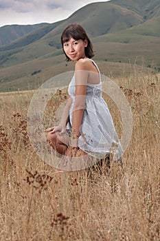 Pretty young lady on a meadow hills