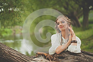 Pretty young model woman in boho style dress at the lake outdoor