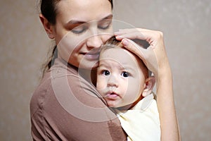 Pretty young mother holding her newborn baby boy. close up