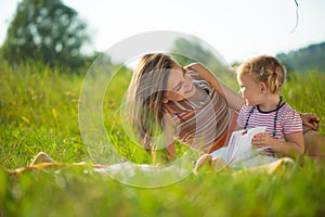 Pretty young mother reading book to her little daughter