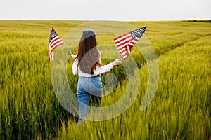 Pretty young pre-teen girl in field holding American flag