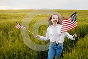 Pretty young pre-teen girl in field holding American flag