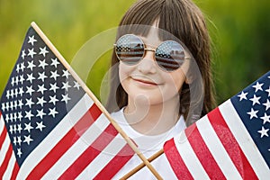 Pretty young pre-teen girl in field holding American flag