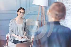 Pretty young psychotherapist meeting teenage patient in office