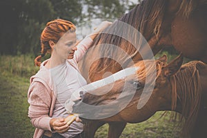 Pretty, young, redhead woman with her lovely horse