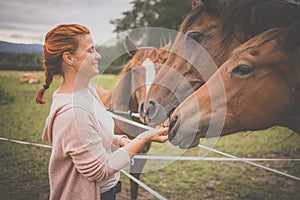 Pretty, young, redhead woman with her lovely horse