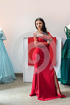 Pretty young sexy model with dark hair in long red dress