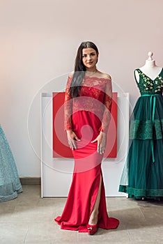 Pretty young sexy model with dark hair in long red dress