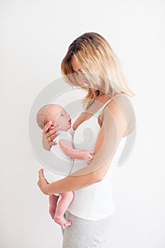 Pretty young smiling mother holding newborn baby