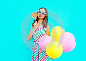 Pretty young smiling woman with an air balloons, lollipop candy