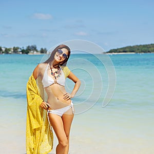 Pretty young tanned woman in bikini posing on the beach