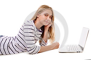 Pretty young teen girl laying on the floor using laptop isolated