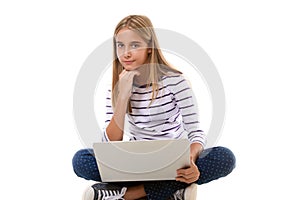 Pretty young teen girl sitting on the floor with crossed legs and using laptop,isolated