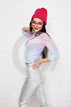 Pretty young teenage girl hipster in pink glasses and hat emotional posing happy smiling, lifestyle people concept