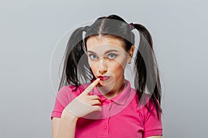 A pretty young teenage girl standing in front of a grey clear empty urban wall background concept gray making funny