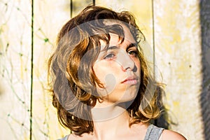 Pretty young teenager girl with curly hair. Light and shadow portrait