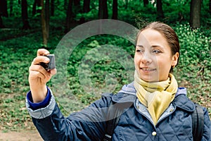 Pretty young traveller blogger girl shoots or records herself on action camera