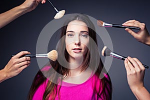 Pretty, young woman in the able care of make-up artist