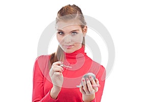 Pretty young woman applying lip gloss