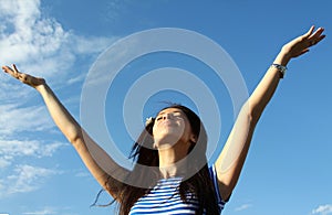 Pretty young woman with arms raised