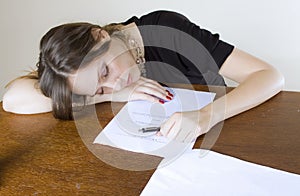 Pretty young woman asleep at the office table