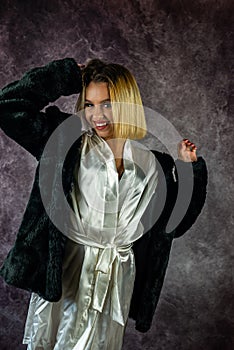pretty young woman in a beautiful light silk robe with a warm fur coat on top.