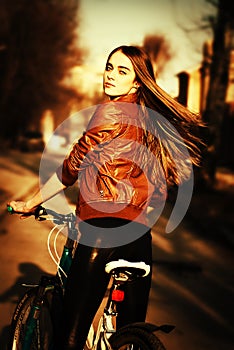 pretty young woman with bicycle in a city road